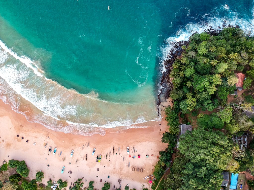 A stunning aerial shot of a vibrant tropical beach in Sri Lanka with lush greenery and turquoise waters.
