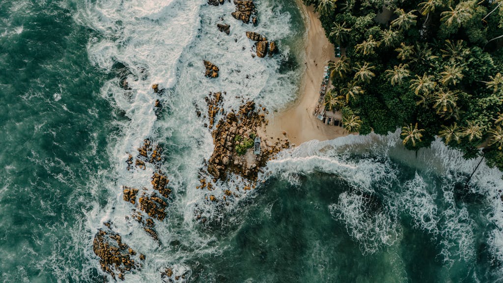 Discover the stunning hidden beach oasis in Sri Lanka captured from above, showcasing lush greenery and turquoise waves.